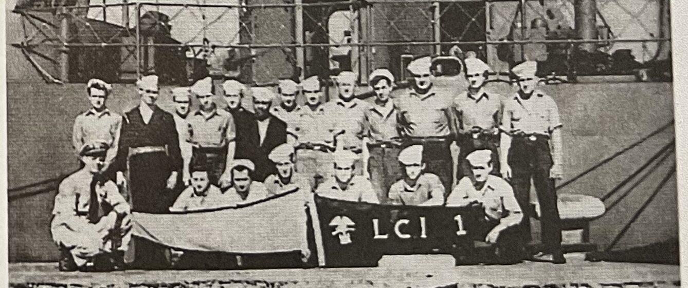 Group photograph of the crew of USS LCI(L)-584 at Oran, Algeria, holding a banner reading LCI 1.